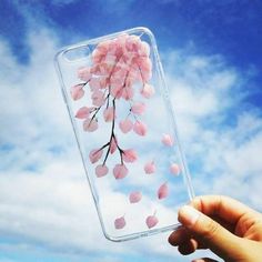 a hand holding up a clear case with pink flowers on it