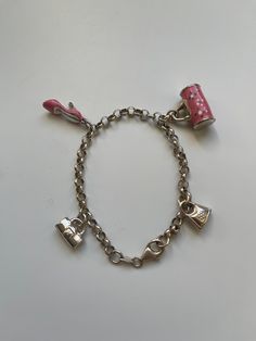 A vintage silver charm cable chain bracelet with 2 pink enamel charms and 2 silver charms. It is marked 925 and come with its original box. It has 4 charms in total: 1 is a pink high heel shoe with silver heel, 1 pink floral handbag with silver handle and flanks and two silver handbags. The whole length of the bracelet is 21cm and can be adjusted to fit any wrist size by click the lobster clasp onto any link of the silver cable chain. It is a piece of vintage jewellery but in a very good condition. No scratches and loss of enamels. Silver Charm Bracelet With Logo For Gift, Silver Charm Bracelet With Logo As Gift, Pink Metal Charm Bracelet With Charms, Pink Metal Charm Bracelet With Removable Charms, Pink Metal Charm Bracelet, Pink Sterling Silver Charm Bracelet With Dangling Charms, Sterling Silver Pink Charm Bracelet With Dangling Charms, Pink Jewelry With Logo Charm For Gifts, Silver Enamel Charm Bracelets