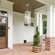 a porch with brick pavers and potted plants