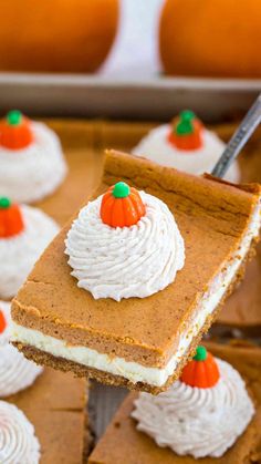 a slice of pumpkin cheesecake being lifted by a fork from a baking pan with other desserts in the background