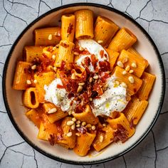 a bowl filled with pasta and sauce on top of a table