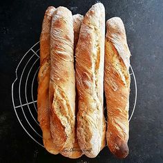 three loaves of bread sitting on top of a wire rack