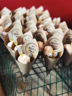 there are many donuts that are on the wire rack and in each one is wrapped with brown paper