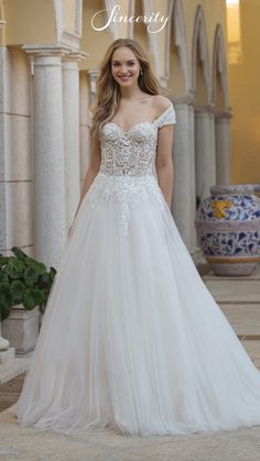 a woman in a wedding dress posing for the camera with her hand on her hip