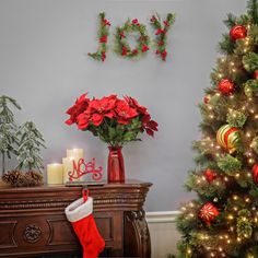 a christmas tree in front of a fireplace with stockings on it