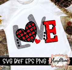 a white shirt with the word love in red and grey plaid on it, sitting next to pine cones