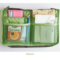 an open green purse with pens, notes and pencils in it's pocket