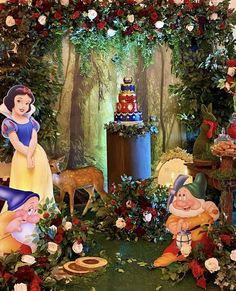 snow white and the seven dwarfs birthday party decoration with flowers, candles and cake on display