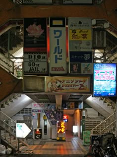 the inside of a building with many signs hanging from it's walls and stairs