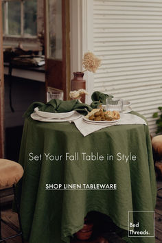 a table covered in green cloths and plates with food on it next to a window