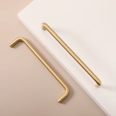 a pair of brass handles on a white surface