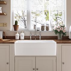 a white kitchen sink sitting under a window