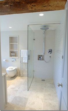 a bathroom with a walk in shower next to a toilet