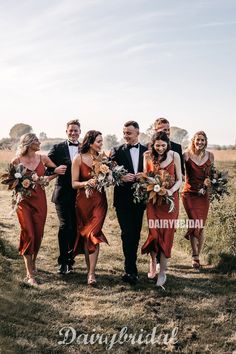 a group of people that are standing in the grass with some flowers on their heads