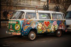 an old vw bus painted with flowers and hearts