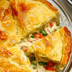 a close up of a pie on a plate with peas and carrots in it