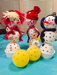 three snowmen sitting on top of a blue table