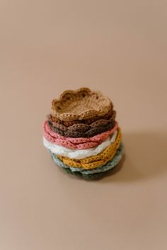 stack of multicolored crocheted coasters on top of each other in the shape of a heart