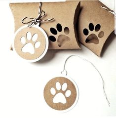 some brown paper with white paw prints on it and two tags attached to the tag