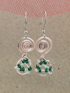 Beautiful and unique, rose gold, green and silver, wire wrapped, spiral, dangle earrings. Handmade using enamelled copper wire, silver plated copper wire and tiny glass beads. These earrings were lovingly designed and crafted at my home studio in the heart of the Norfolk Broads National Park. Each piece of jewellery is handmade therefore no two pieces are the same. This means each earring, although a pair, will not be absolutely identical, but each piece will be unique. The ear wires are handmad Silver Teardrop Jewelry With Copper Wire, Silver Teardrop Jewelry In Copper Wire, Whimsical Wire Wrapped Metal Jewelry, Green Bohemian Earrings With Copper Wire, Bohemian Green Earrings With Copper Wire, Green Copper Wire Earrings Gift, Green Bohemian Copper Wire Earrings, Teardrop Copper Wire Wrapped Jewelry, Bohemian Nickel-free Wire Jewelry