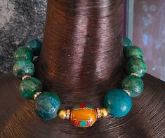 "Lovers of Turquoise will recognize the value of these big, bold, chunky and heavy Chrysocolla beads (faux turquoise) which gives you all the dramatic styling without the exorbitant price.  This 18\" non-adjustable Choker features ten gumball size blue green Chrysocolla beads, each of which is spaced with a brilliant rhinestone rondelle adding light to the piece.  A single Tibetan Resin focal bead sits in the front and adds contrast.  The back is finished with bronze rounds, faceted crystals and Iris Apfel Style, Boho Couture, Styled Jewelry, Jewellery Shop Design, Polymer Clay Flower Jewelry, Turquoise Choker, Exotic Jewelry, Turquoise Statement Necklace, Beaded Statement Necklace