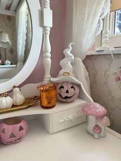 there is a mirror and some pumpkins on the shelf in this room with pink walls