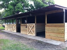 several horse stalls are lined up in the grass