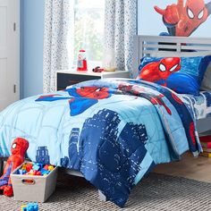 a child's bedroom with spiderman bedding and toys