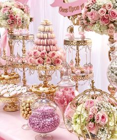 a table topped with lots of pink and white desserts