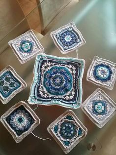 crocheted squares are arranged on a glass table in the shape of an ornament