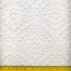 the white quilt is being measured by a ruler