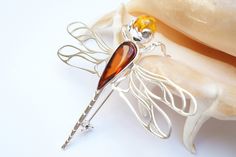 This is a beautiful 925 sterling silver, unique, handmade, high quality natural baltic amber dragonfly brooch. Brooch height is 5,6 cm-2,20 inch, width 6,5 cm - 2,55 inch. Weight is 7,2 grams Perfect to wear or gift. This item comes with certificate of authenticity. We only sell products made of natural Baltic Amber. For more unique and best quality items, please visit: https://www.etsy.com/uk/shop/ClassyJewelleryBox?ref=hdr_shop_menu We guarantee 100% quality of our items. Dragonfly Brooch Jewelry As A Gift, Dragonfly Brooch Jewelry Gift, Dragonfly Brooch Jewelry For Gift, Elegant Dragonfly Brooch For Gift, Elegant Dragonfly Brooch As Gift, Dragonfly Pin, Dragonfly Brooch, Amber Jewelry, Jewellery Gift