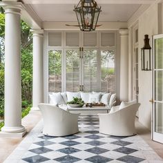 a porch with white furniture and black and white checkered flooring