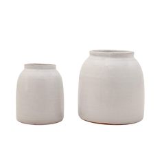 two white vases sitting next to each other