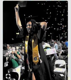 a woman in a graduation gown is throwing confetti into the air