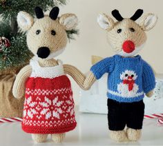 two knitted mice holding hands in front of a christmas tree