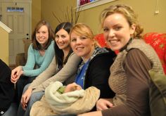 a group of women sitting on top of a red couch