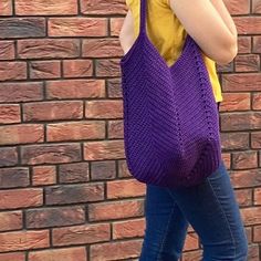 a woman is standing in front of a brick wall and talking on her cell phone