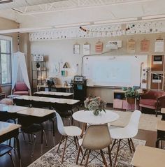 an empty classroom with desks, chairs and a whiteboard on the wall in front of it