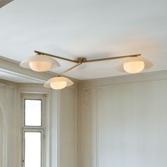 three lights are hanging from the ceiling in an empty room