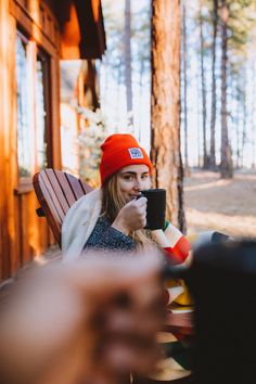 a woman sitting in a chair drinking from a cup