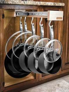 an image of pots and pans hanging on the rack in front of kitchen cabinets