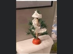 a small christmas tree sitting on top of a toilet