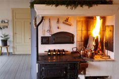 an old fashioned stove is lit up in the kitchen