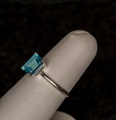 a ring with an emerald colored stone on it