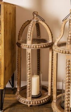 two wooden birdcages sitting next to each other on top of a wood floor