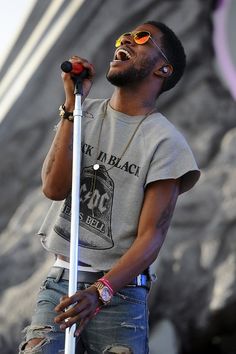 a man singing into a microphone on stage