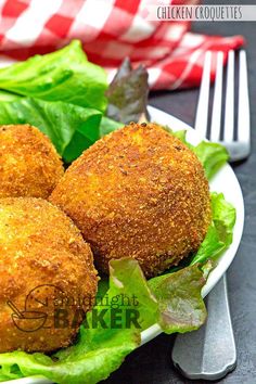 three fried meatballs on a plate with lettuce