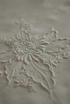 an intricately designed bed spread with white thread