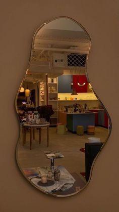 a mirror that is on the wall in front of a table with a vase and other items